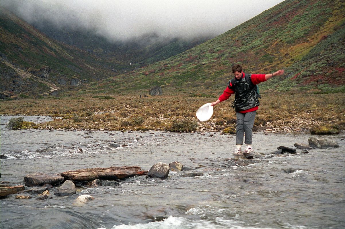 26 Shane Teeters Across The Rocks And Logs In The River Almost To Camp At Joksam Tibet